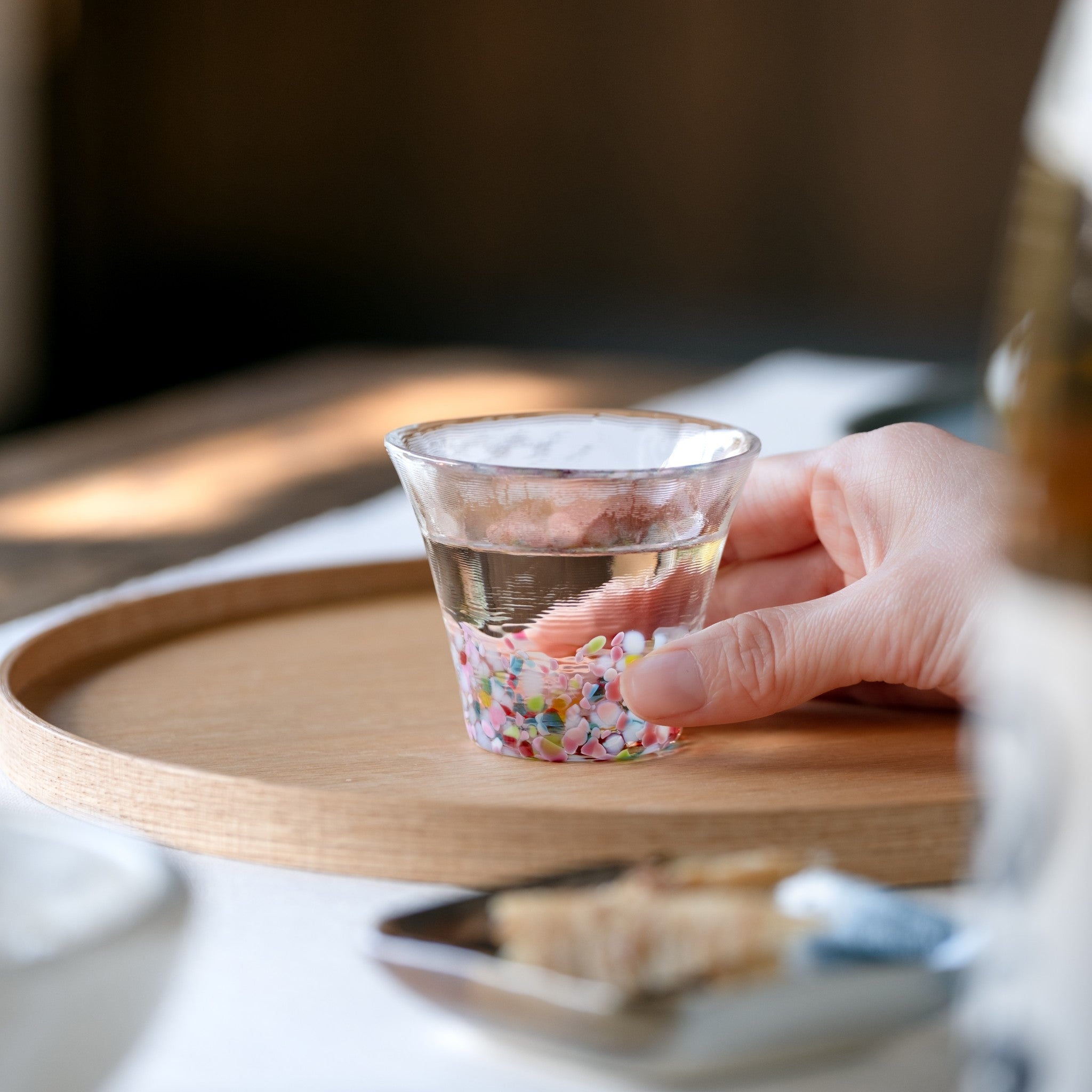 津軽びいどろ にほんの色 ふうけい 盃 春の丘 日本酒が注がれたガラスおちょこ