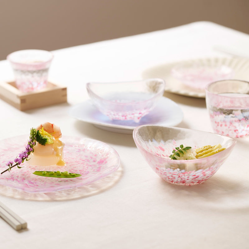 津軽びいどろ さくらさくら sakura三つ足楕円小鉢 食卓にガラス食器やガラスのおちょこが並んでいる画像