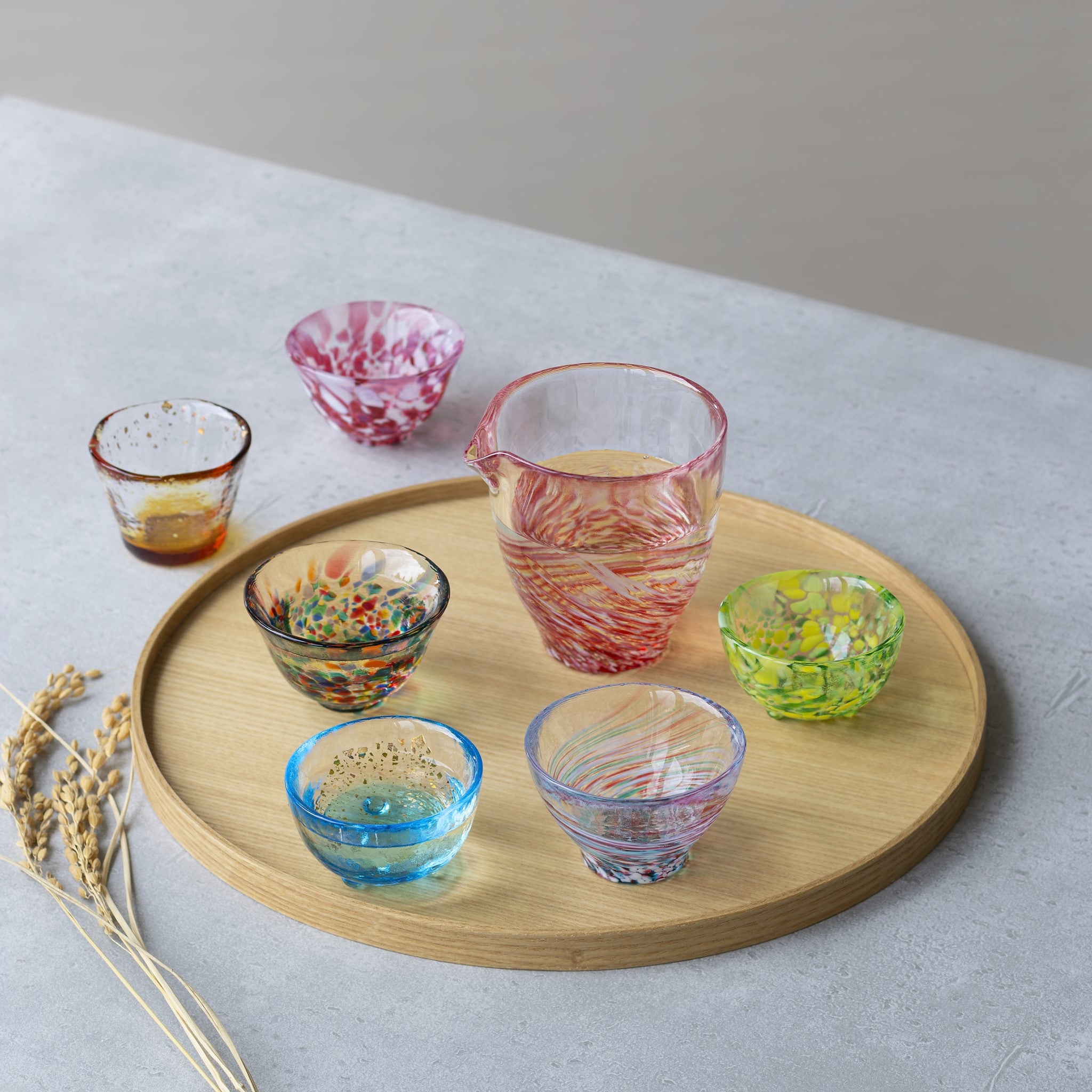 津軽びいどろ 盃コレクション 盃朝の露 お盆の上にカラフルな盃がたくさんのっている画像