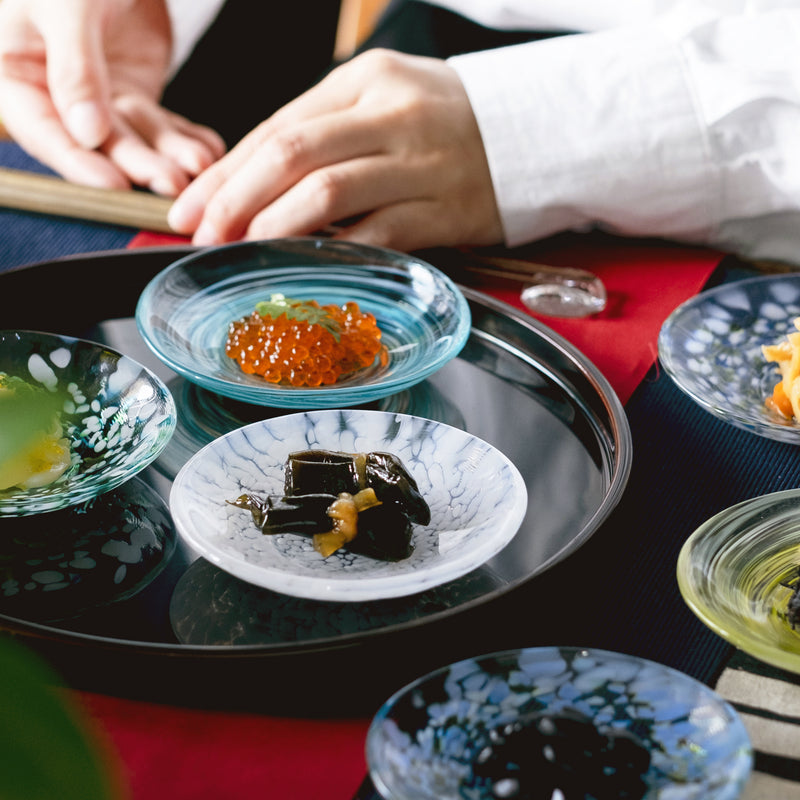 津軽びいどろ 色色豆皿 淡雪 いろいろな料理が乗った小皿が食卓に並んでいる画像