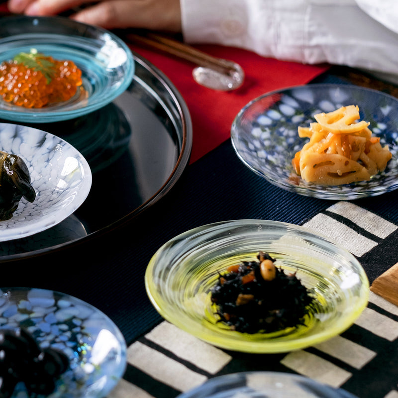 津軽びいどろ 色色豆皿 菜の花 料理が乗った小皿がテーブルに並んでいる画像