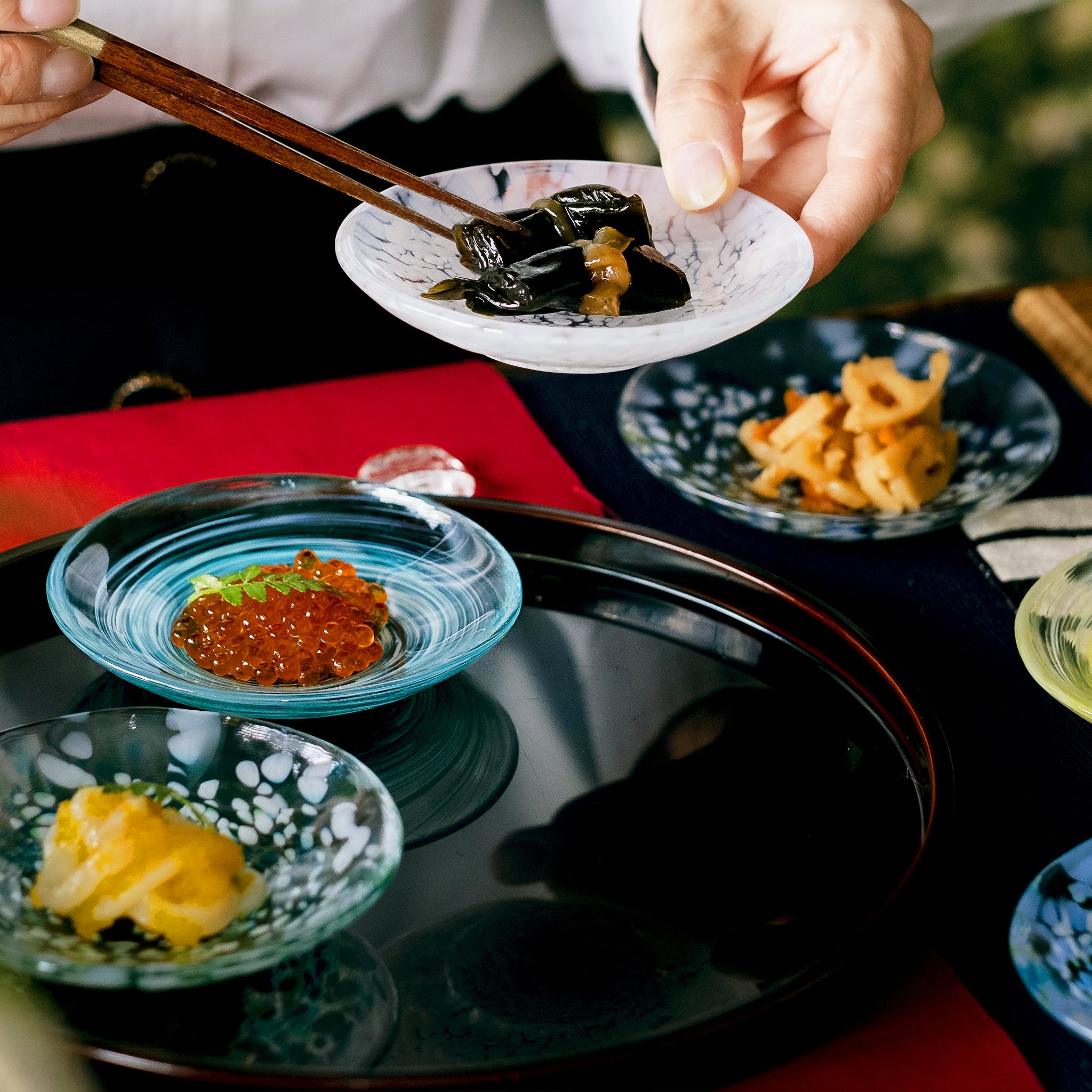 津軽びいどろ 色色豆皿 若葉 料理が乗った小皿を手で持ち上げている画像