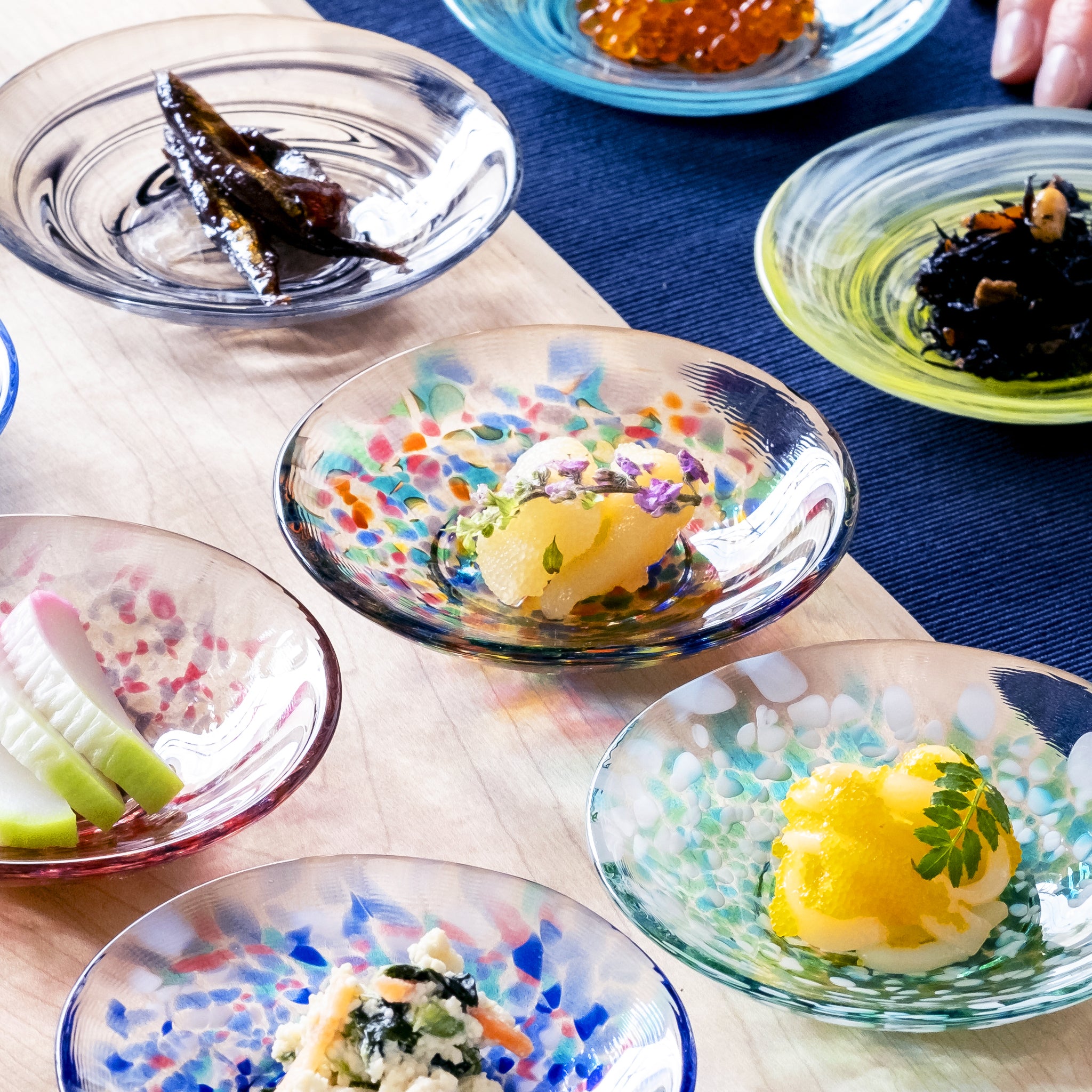 津軽びいどろ 色色豆皿 ねぶた夜祭 料理が乗った色違いの小皿が並んでいる画像