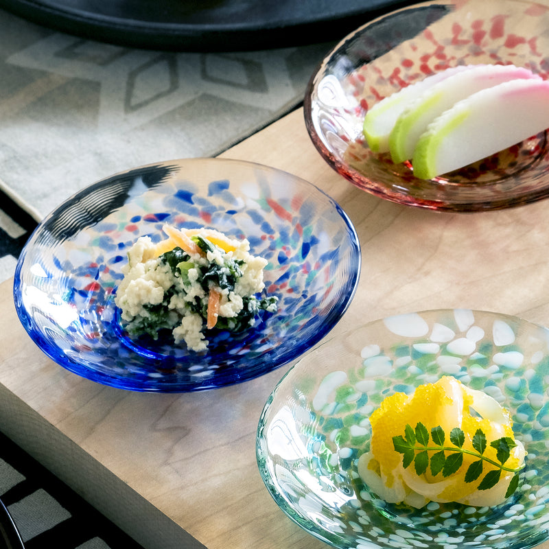 津軽びいどろ 色色豆皿 夏海 料理が乗った小皿がテーブルに並んでいる画像