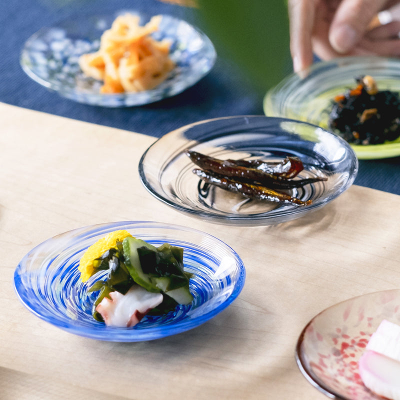 津軽びいどろ 色色豆皿 夏海 料理が乗った小皿に手を添えている画像