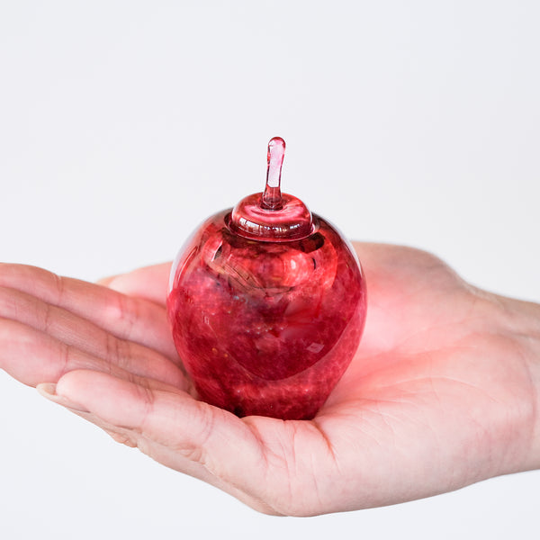 津軽びいどろ ちいさな林檎 りんご インク壺赤 インクポットを手の平に乗せている画像