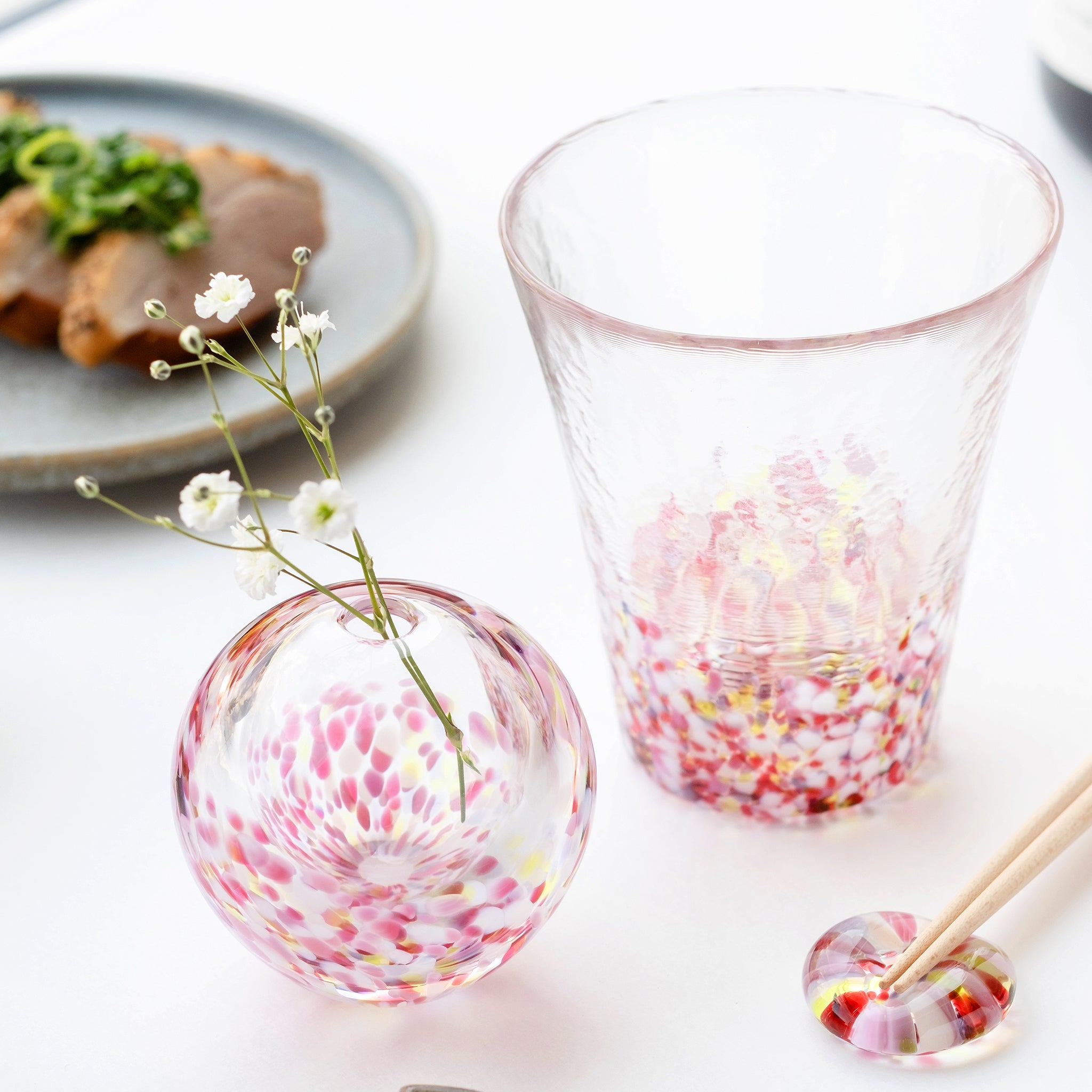 津軽びいどろ にほんの色ふうけい 一輪挿し 舞う桜 切り花が活けられた花瓶が食卓に並んでいる画像