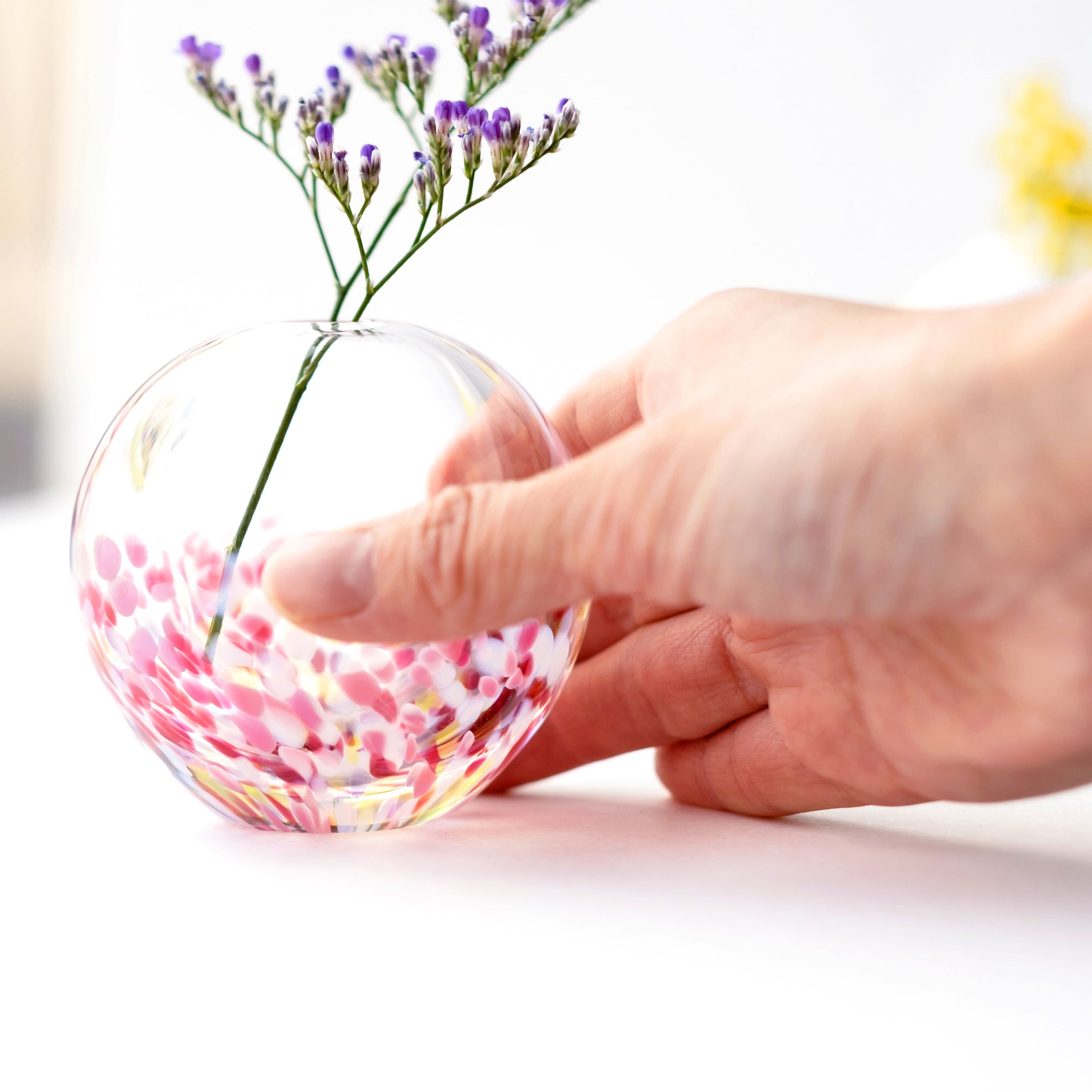 津軽びいどろ にほんの色ふうけい 一輪挿し 舞う桜 切り花が活けられた花瓶を手で持っている画像