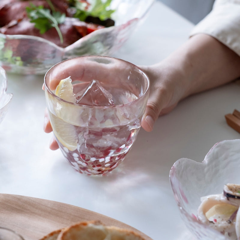 津軽びいどろ 津軽自然色りんご あかりんごカップ レモン水が注がれたグラスを手で持っている画像