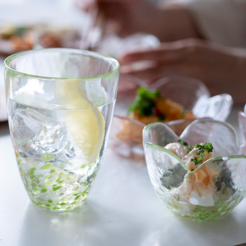 津軽びいどろ 津軽自然色りんご あおりんごタンブラー レモン水が注がれたグラスが食卓に並んでいる画像