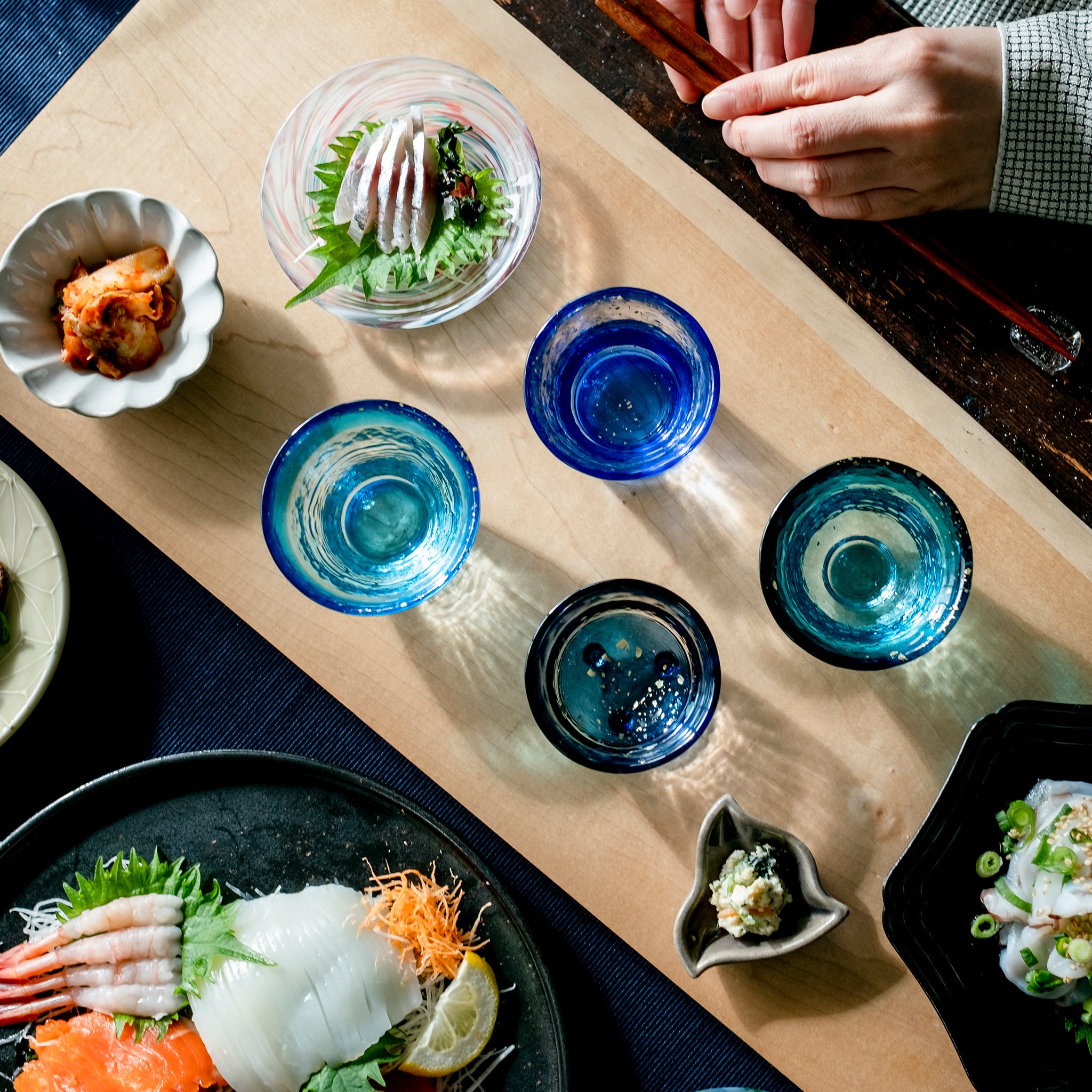 津軽びいどろ あおもりの海 盃セット 色違いの盃が食卓に並んでいる画像