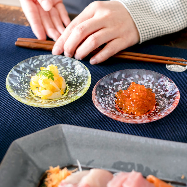 津軽びいどろ 豆皿ギフト  りんご豆皿ペアセット 色違いのガラス食器に料理がよそわれている画像