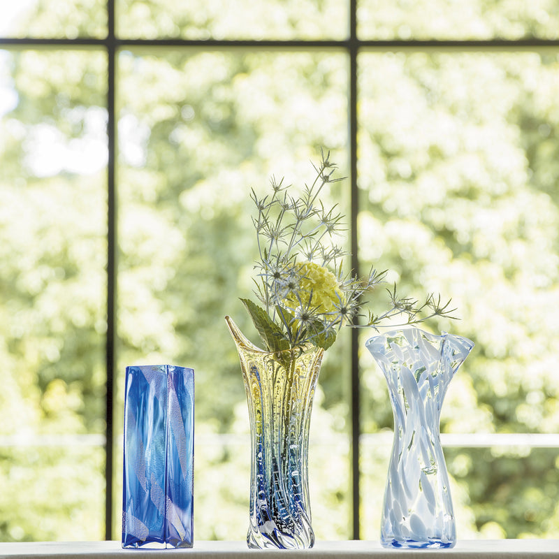 津軽びいどろ ストレート 花器角ブルー金 様々な花瓶がテーブルに並んでいる画像