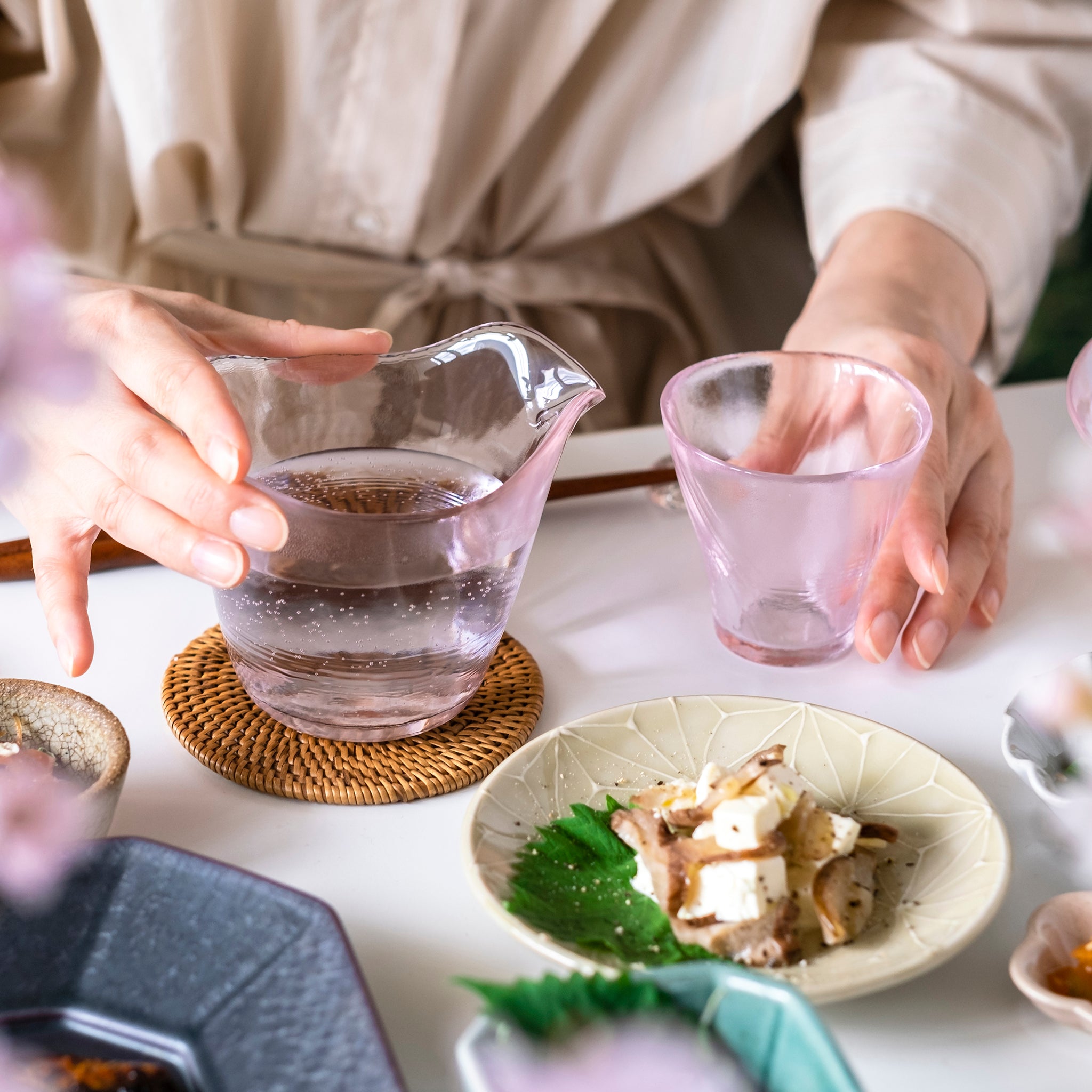 津軽びいどろ 耐熱さくら 耐熱片口 盃に片口で日本酒を注ごうとしている画像