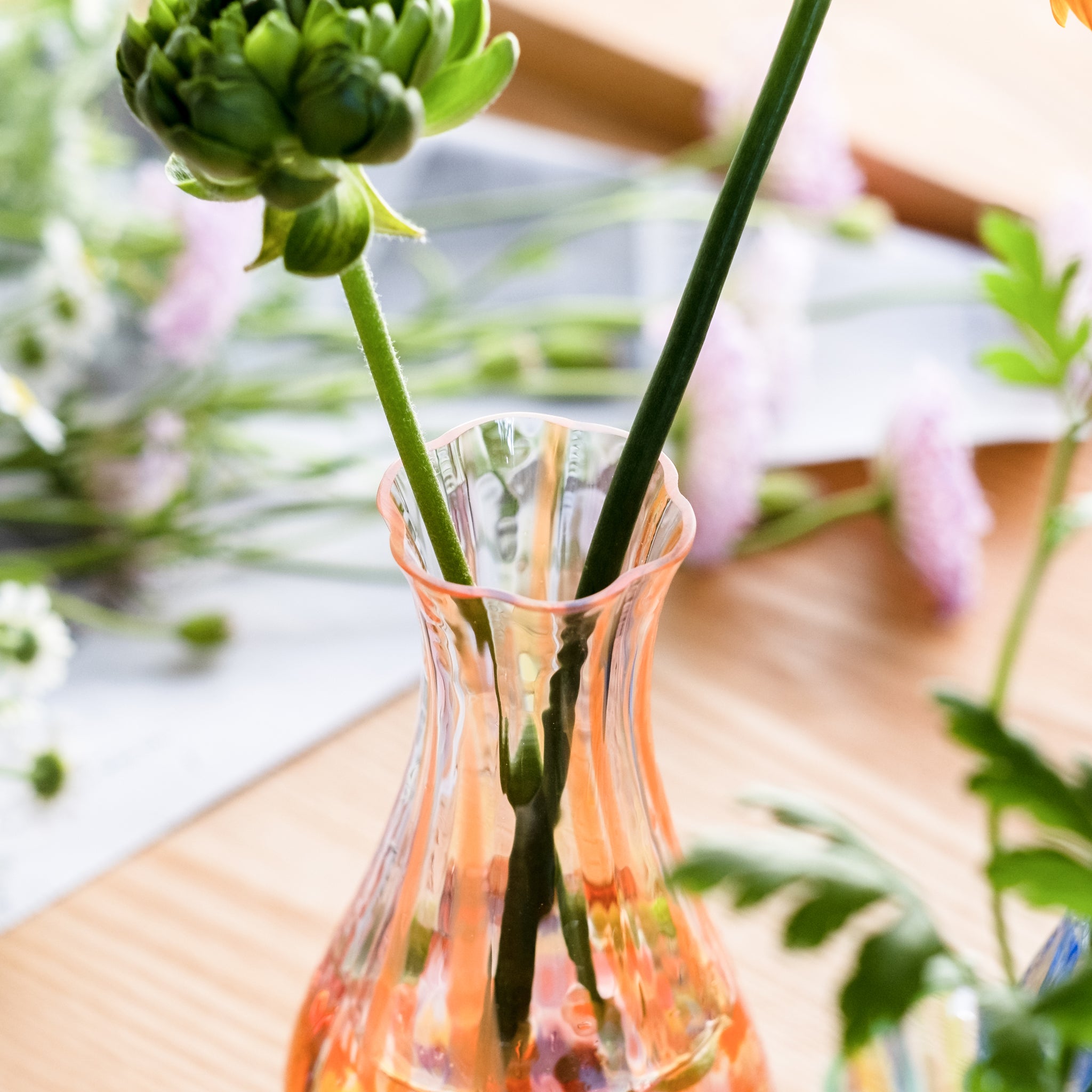 津軽びいどろ 花ひかり サンセットオレンジ 一輪挿し 花が活けられた一輪挿しの画像